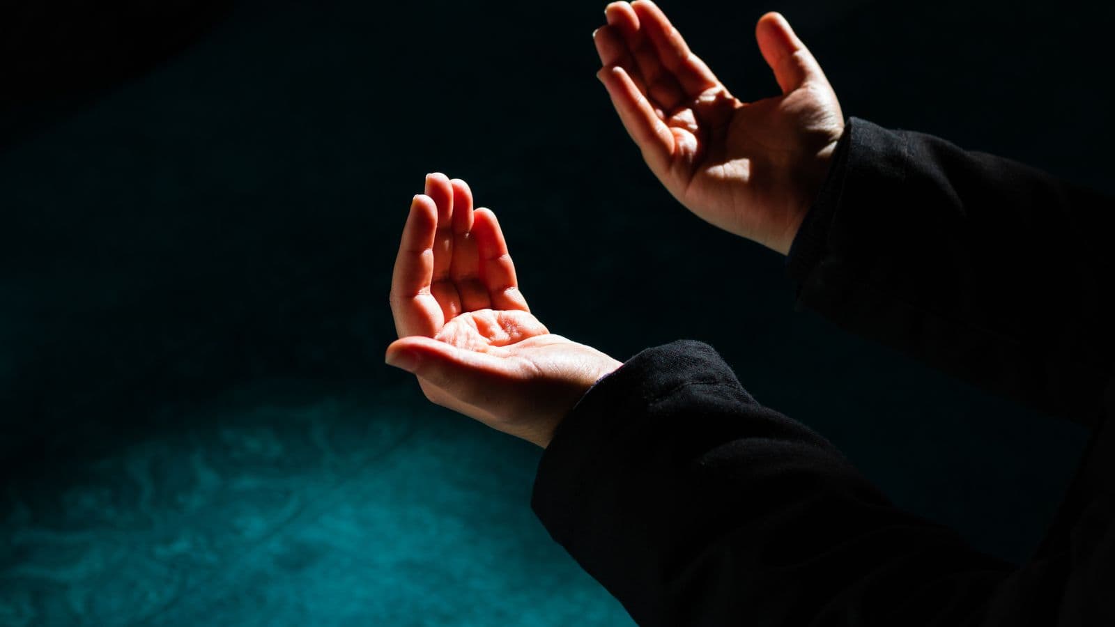 Mains levées pour une invocation sur un fond sombre