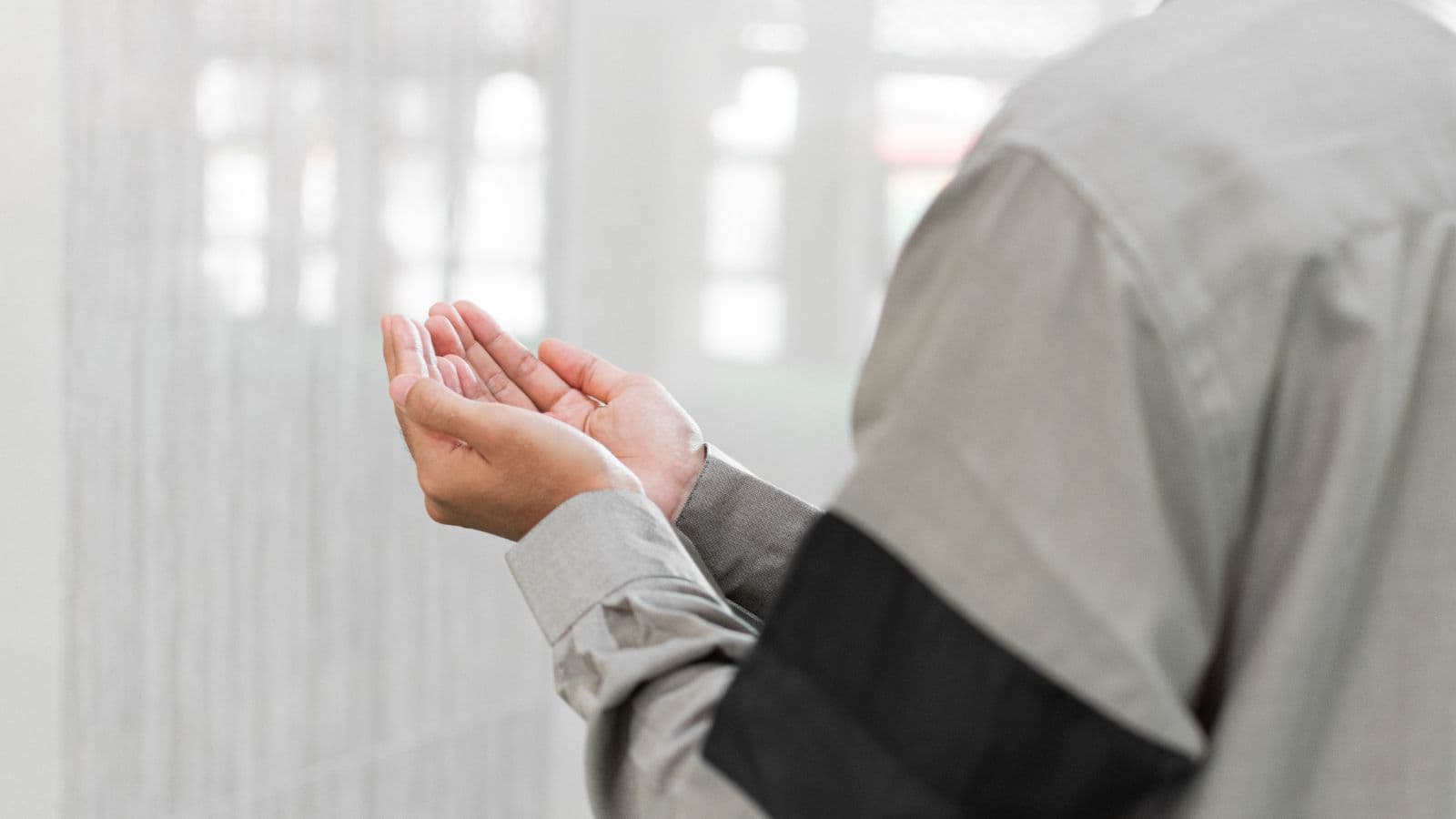 Femme vue de dos levant les mains pour une invocation