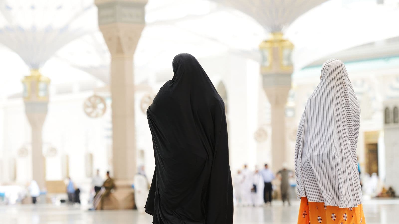 Deux femmes vues de dos dans la cour d'une mosquée