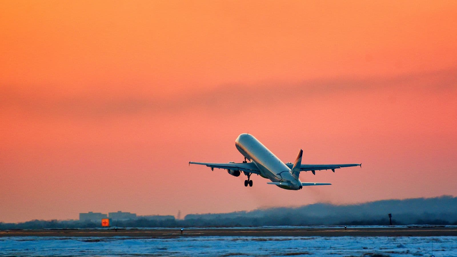 Avion décollant devant un ciel rose