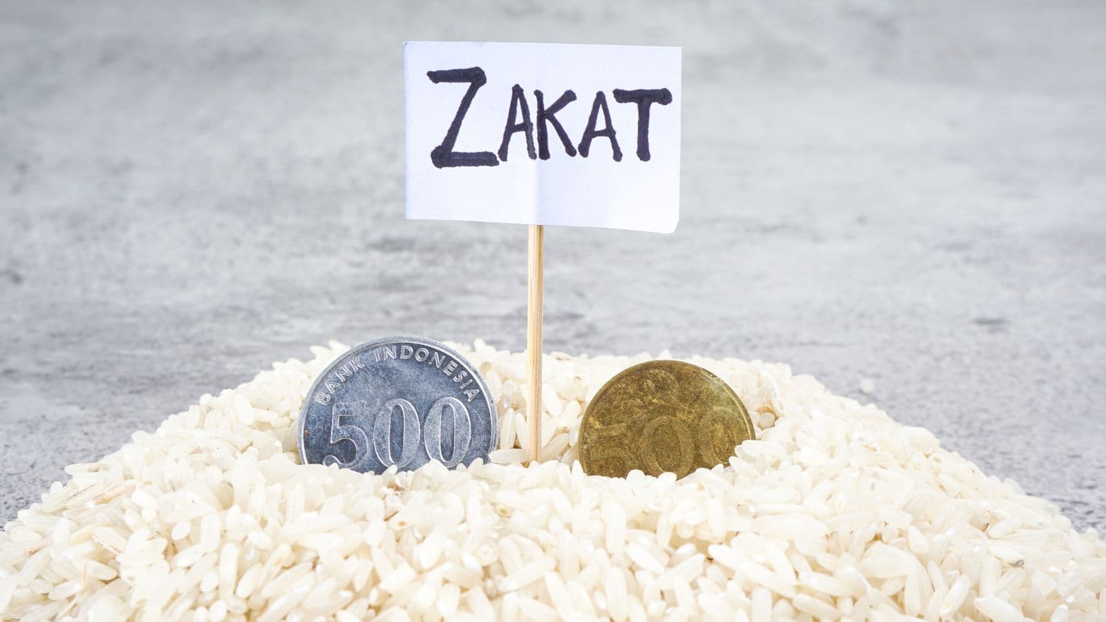 Riz et pièces de monnaie sous une pancarte Zakat