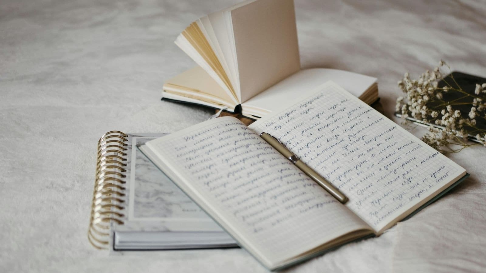 Carnets ouverts, plume et feuilles de travail sur un bureau