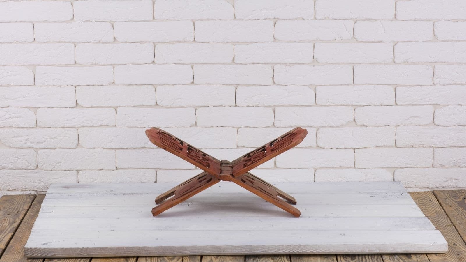 Pupitre vide sur une table blanche devant un mur de briques
