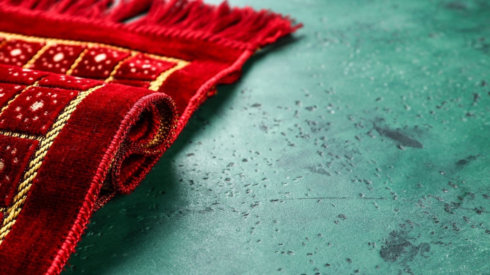 Tapis de prière rouge partiellement déroulé