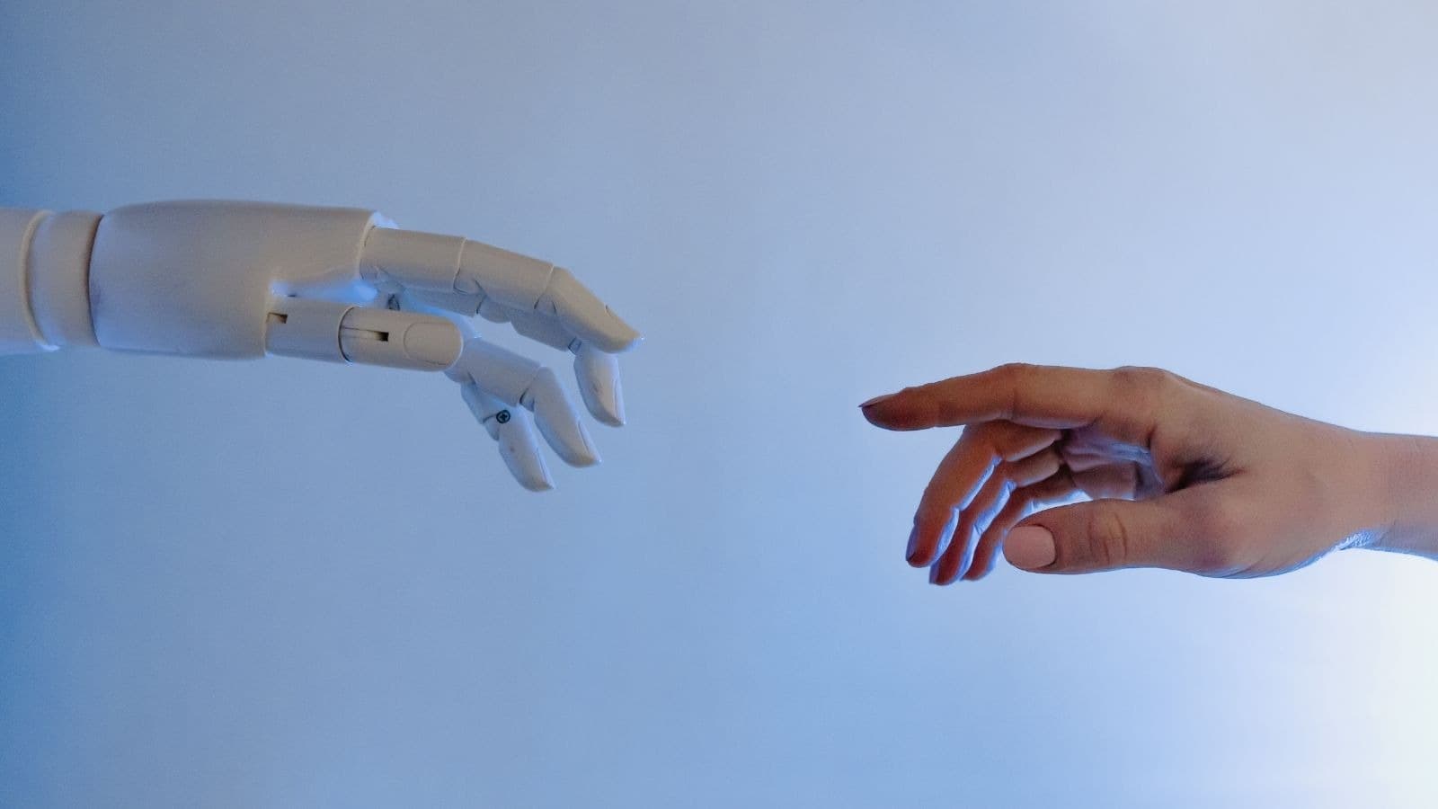 Main humaine tendue vers une main robotique