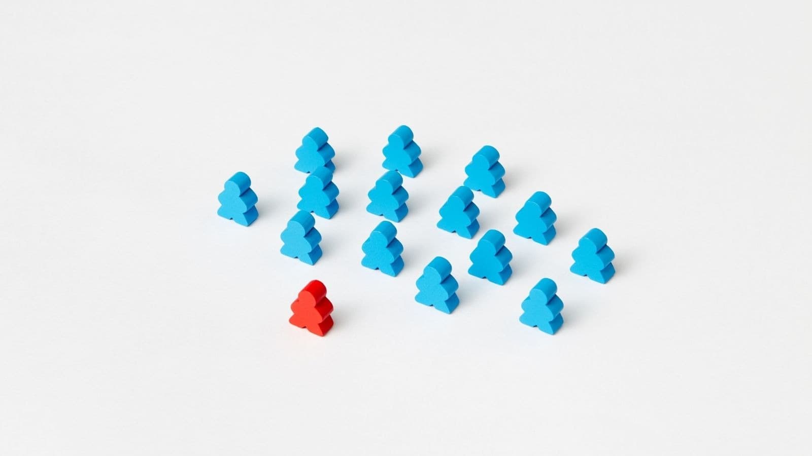 Figurine rouge devant un groupe de figurines bleues