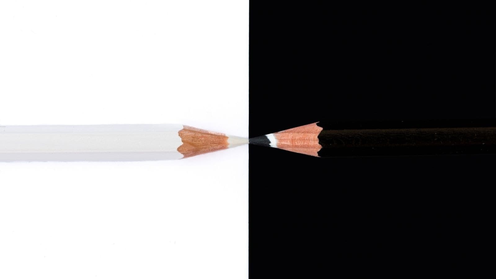 Deux crayons opposés sur des fonds blanc et noir