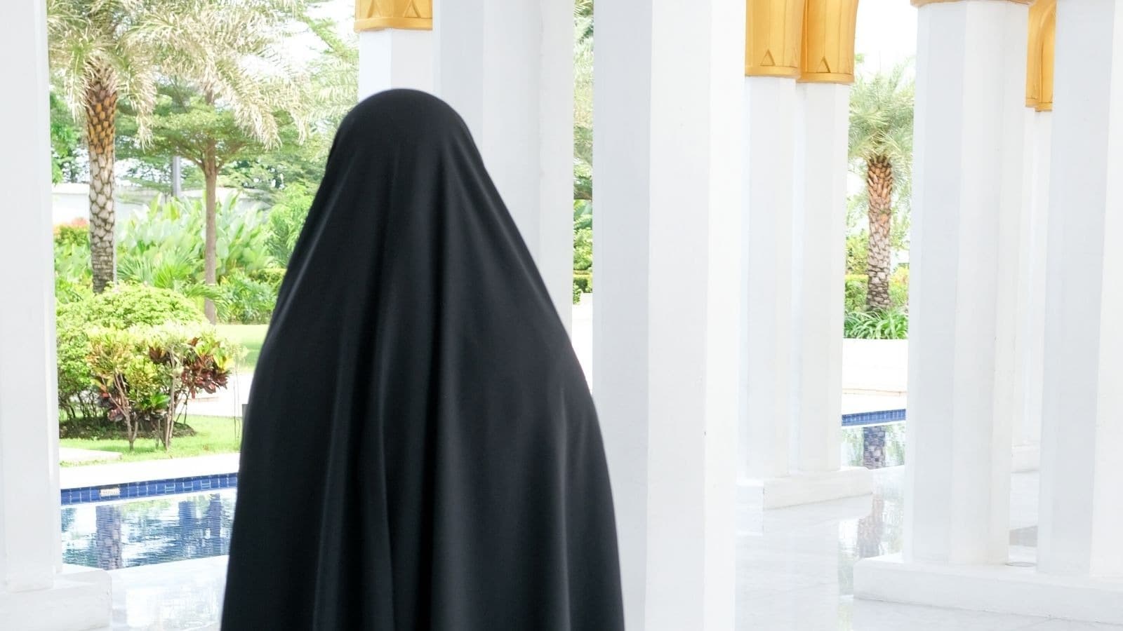Femme voilée de dos dans un intérieur lumineux
