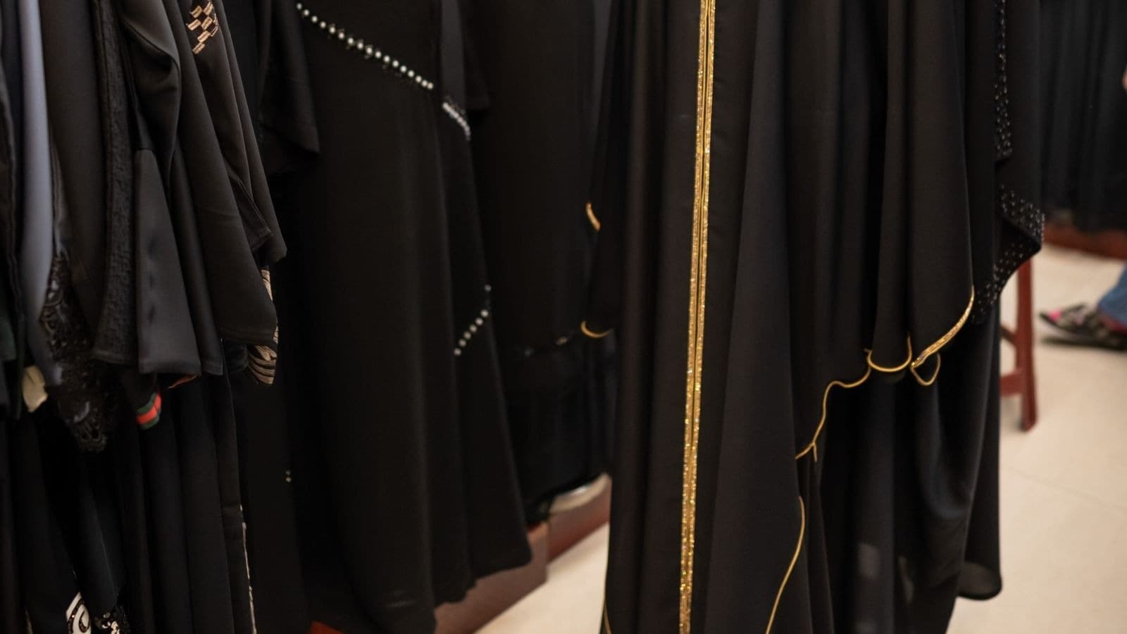 Rangée de vêtements noirs aux broderies dorées