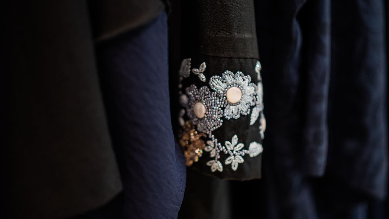 Détail de broderies florales sur des tissus sombres