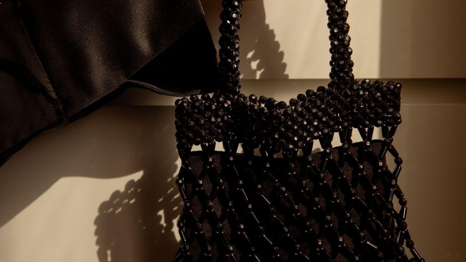 Sac noir perlé accompagné d'un tissu sombre