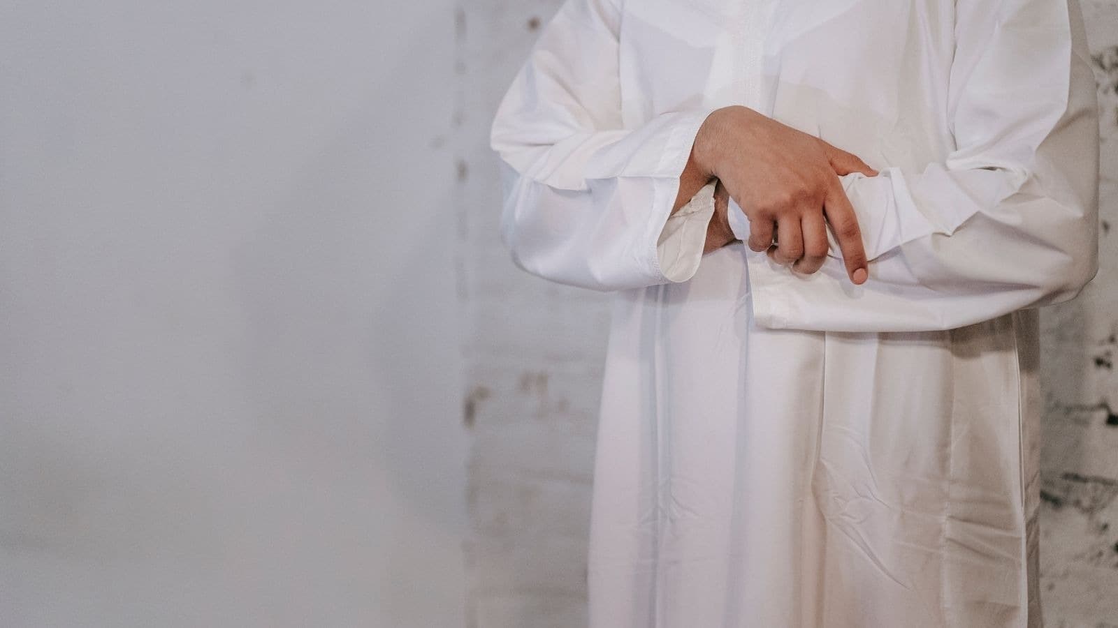 Homme en vêtement blanc ajustant sa manche