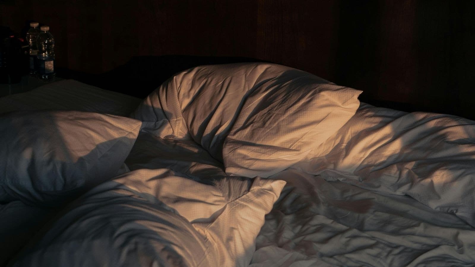 Lit vide aux draps sombres et froissés
