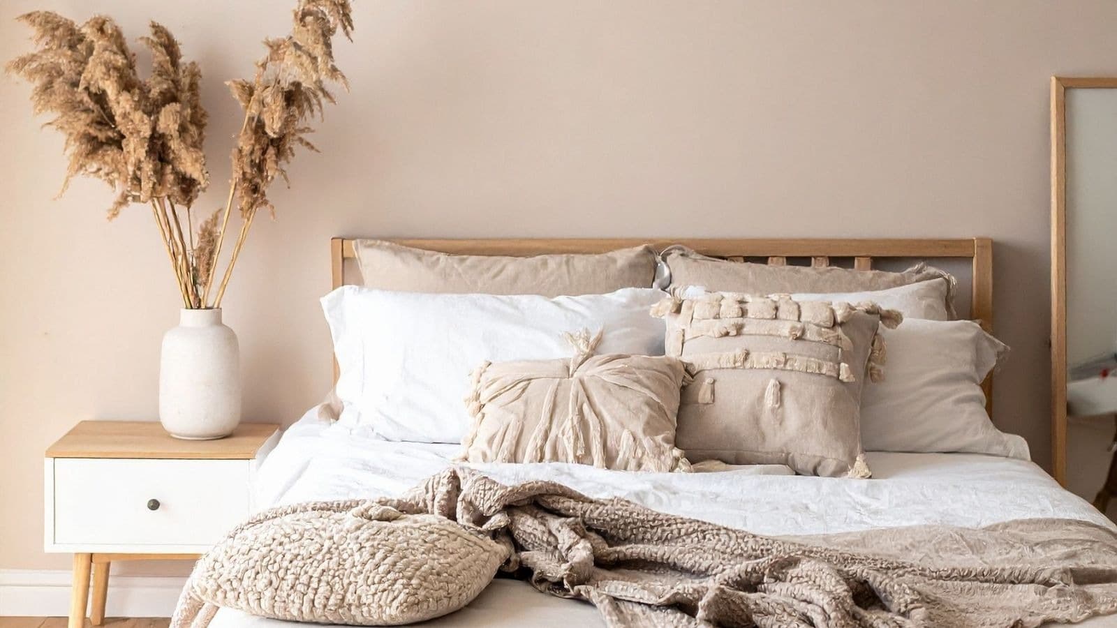 Lit beige dans une chambre chaleureuse et calme