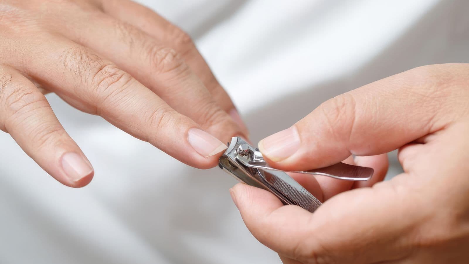 Main dont les ongles sont coupés avec un coupe-ongles