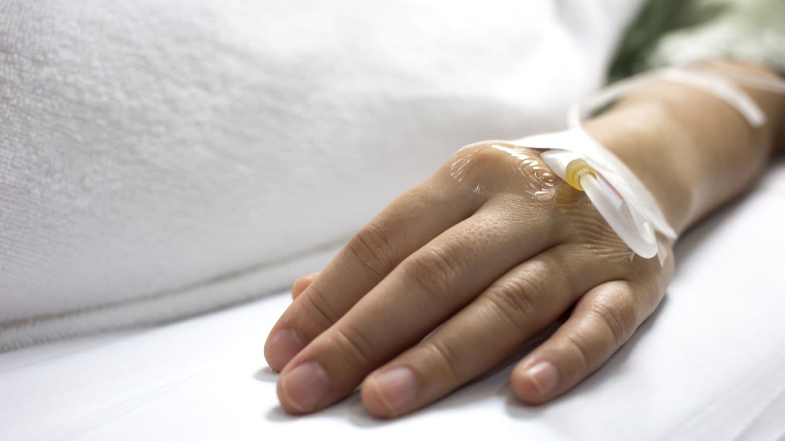 Main d'une personne hospitalisée reliée à une perfusion