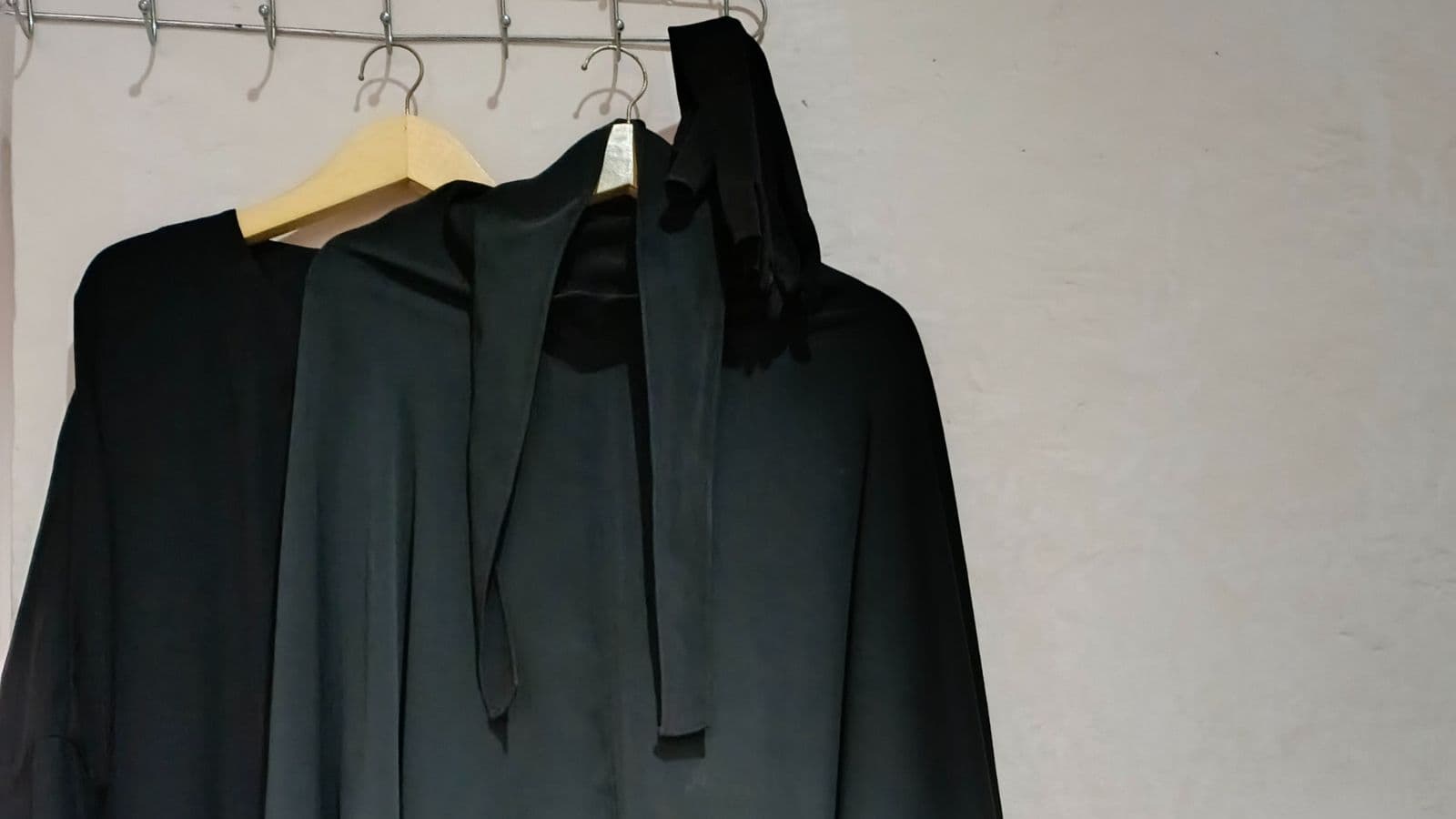 Vêtement noir et voile suspendus sur un cintre