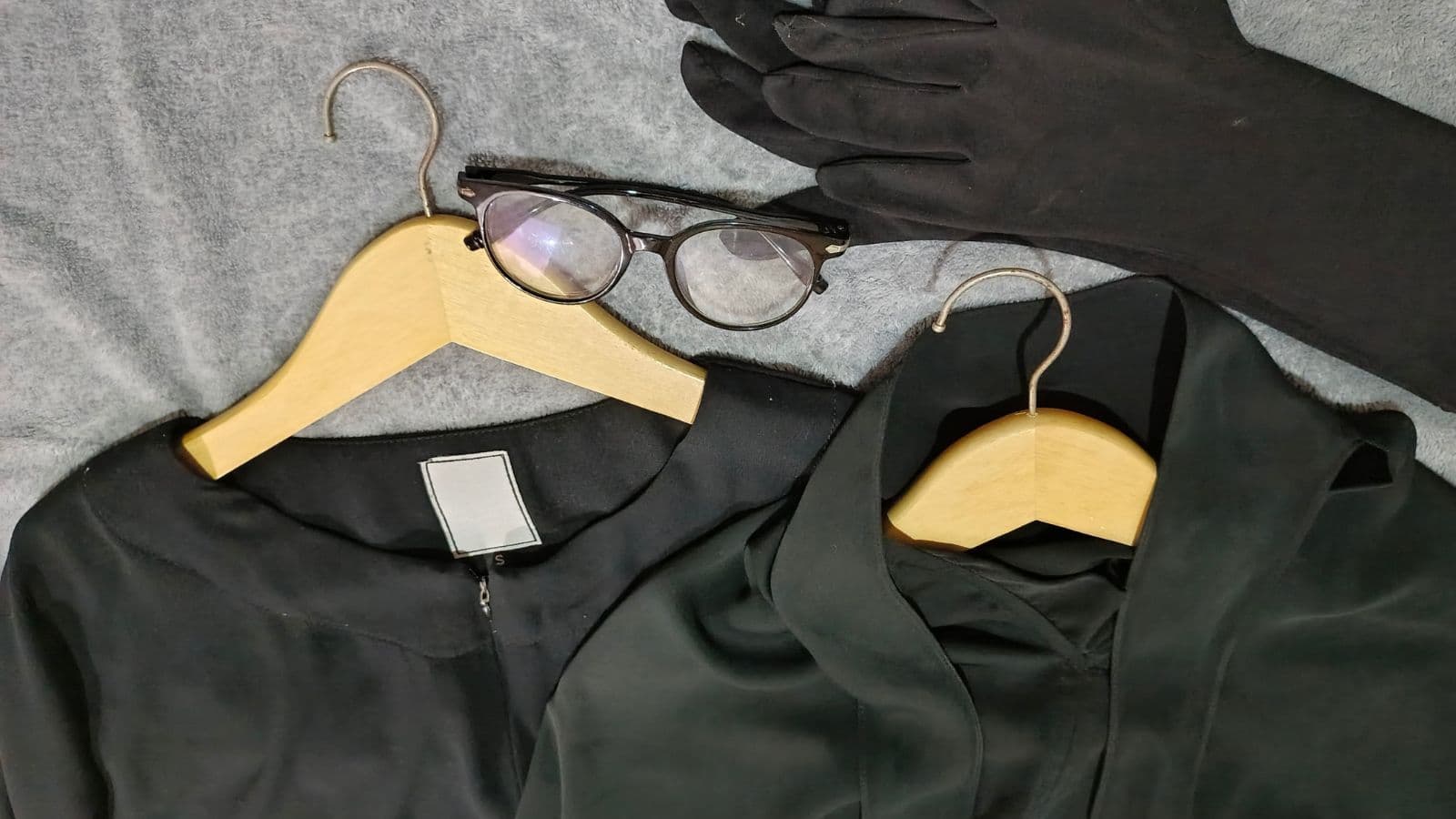 Vêtements noirs et accessoires féminins disposés sur des cintres