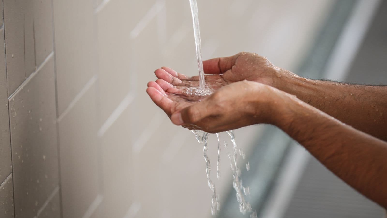 Mains recueillant de l'eau pendant les ablutions