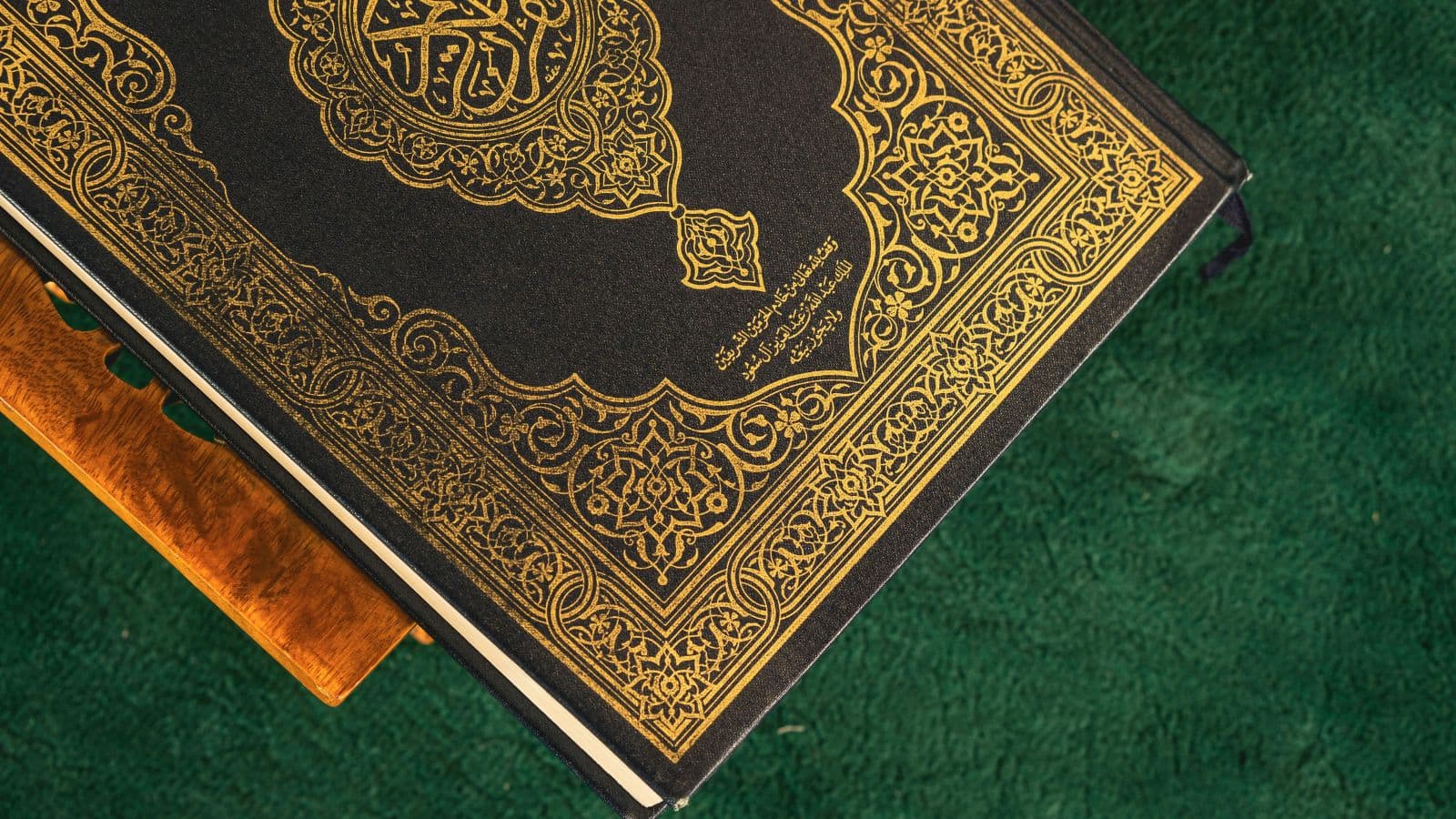 Coran fermé à la couverture verte posé sur un tapis
