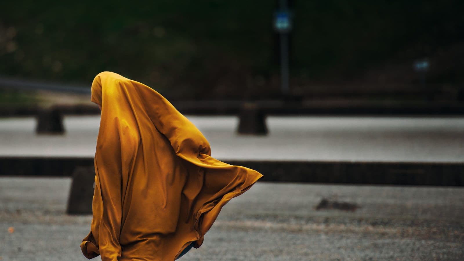 Femme assise en tenue de prière, visage entièrement couvert