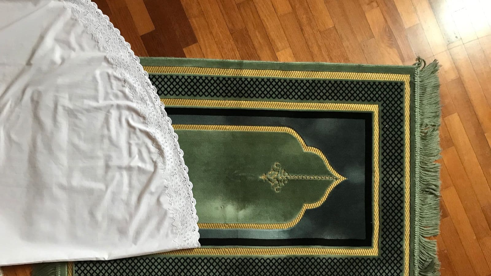 Tapis de prière vert installé dans un intérieur calme