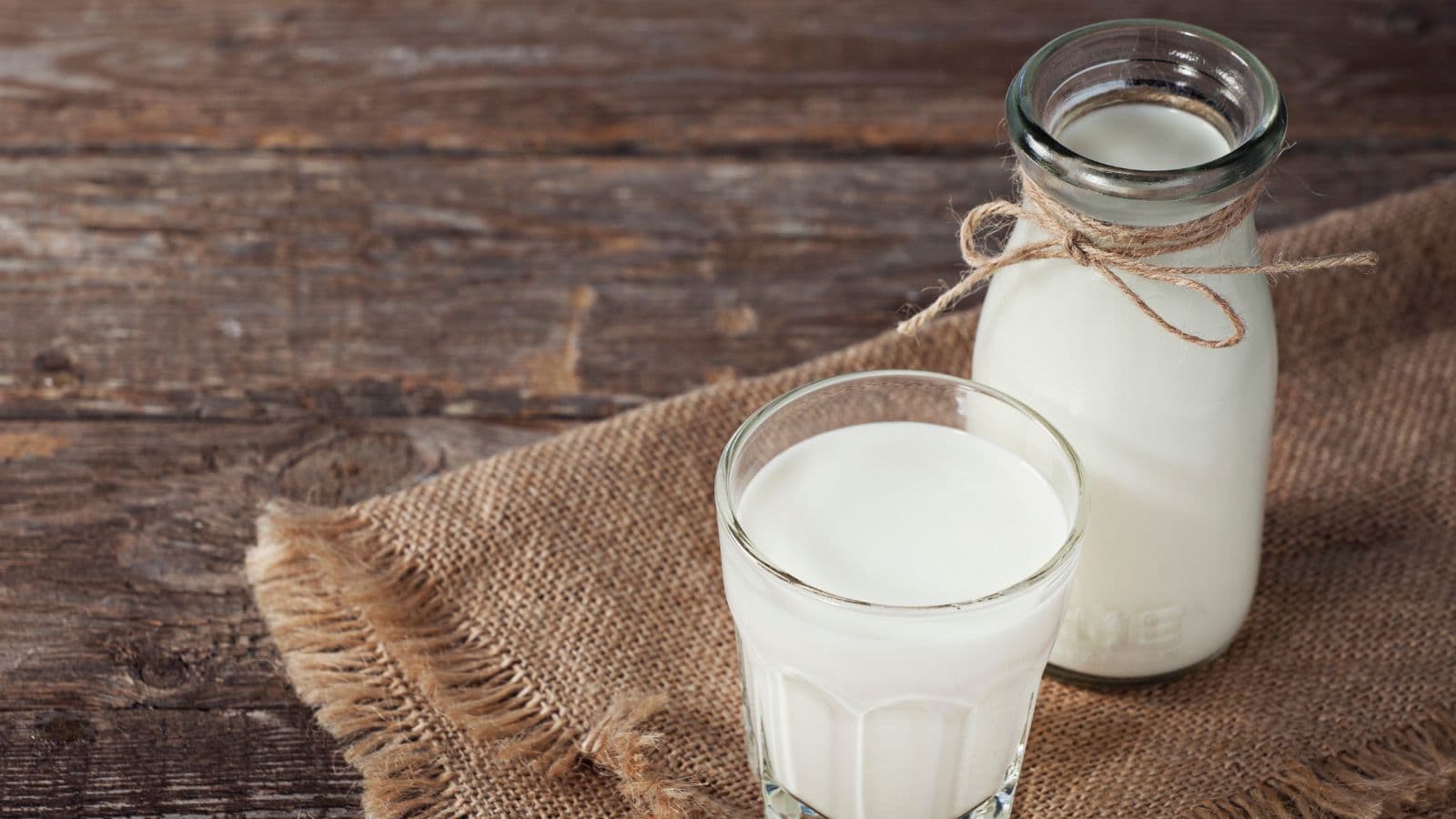Verre et bouteille de lait sur une table en bois