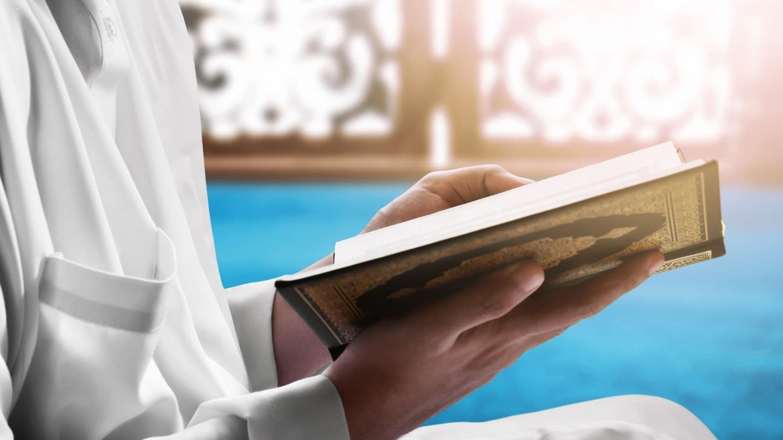 Lecteur en vêtement blanc tenant un Coran ouvert