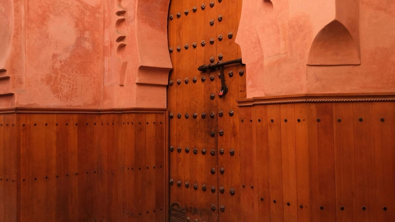 Grande porte en bois dans une façade ocre