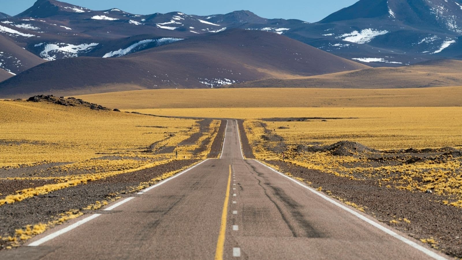 Route droite traversant un vaste paysage de montagne