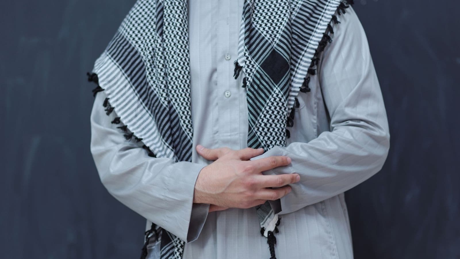 Homme en vêtement blanc portant un keffieh noir et blanc
