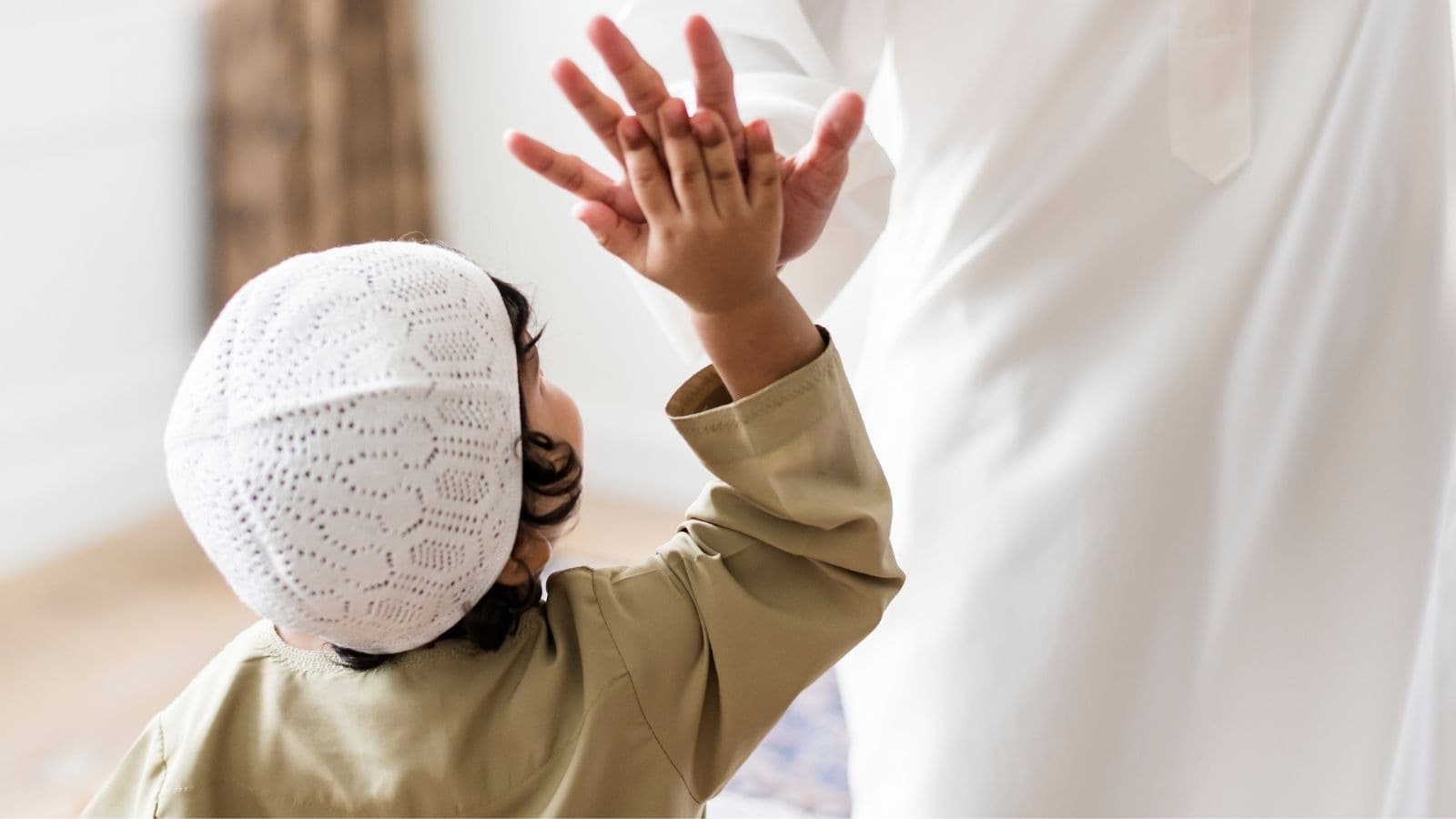 Enfant en tenue de prière levant une main