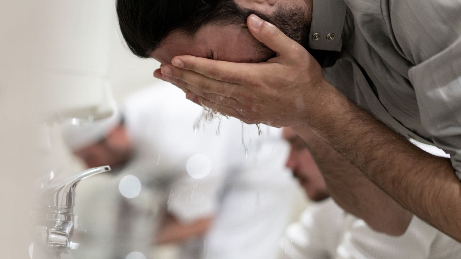 Personne se lavant le visage pendant les ablutions