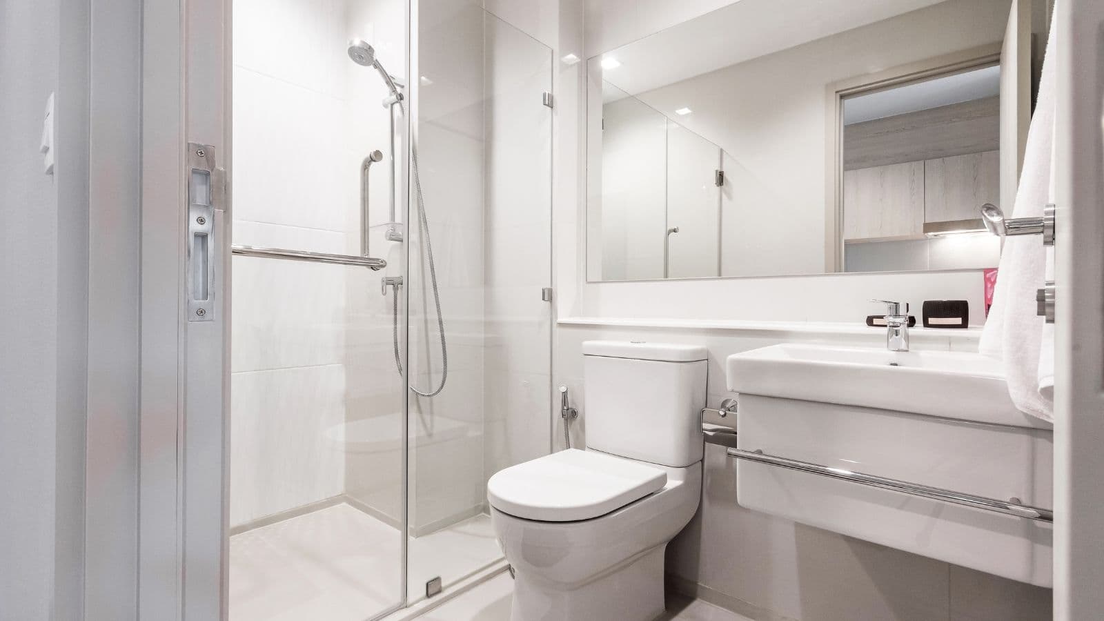 Salle de bain claire avec douche, lavabo et toilettes