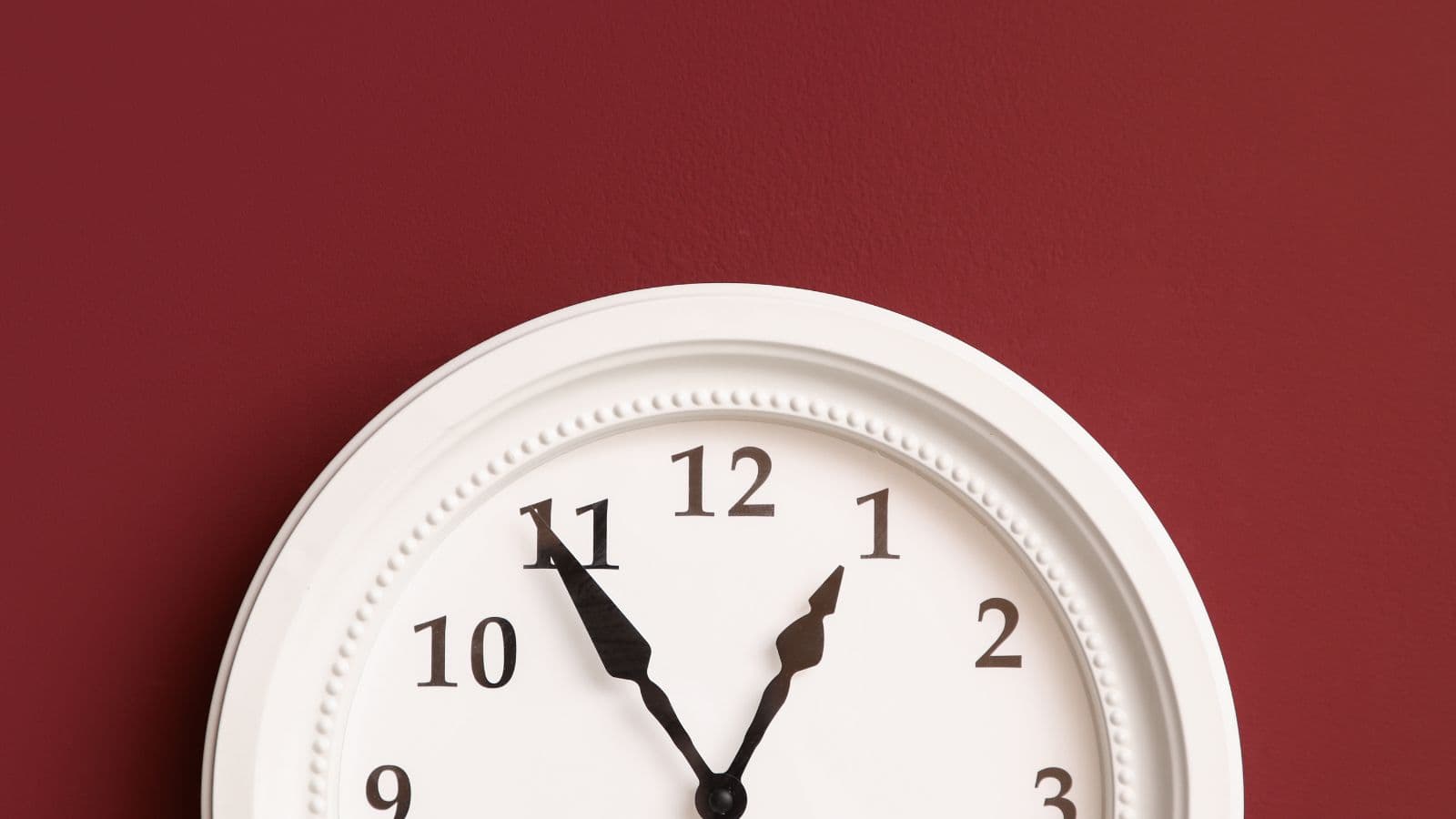 Horloge murale blanche sur un mur rouge