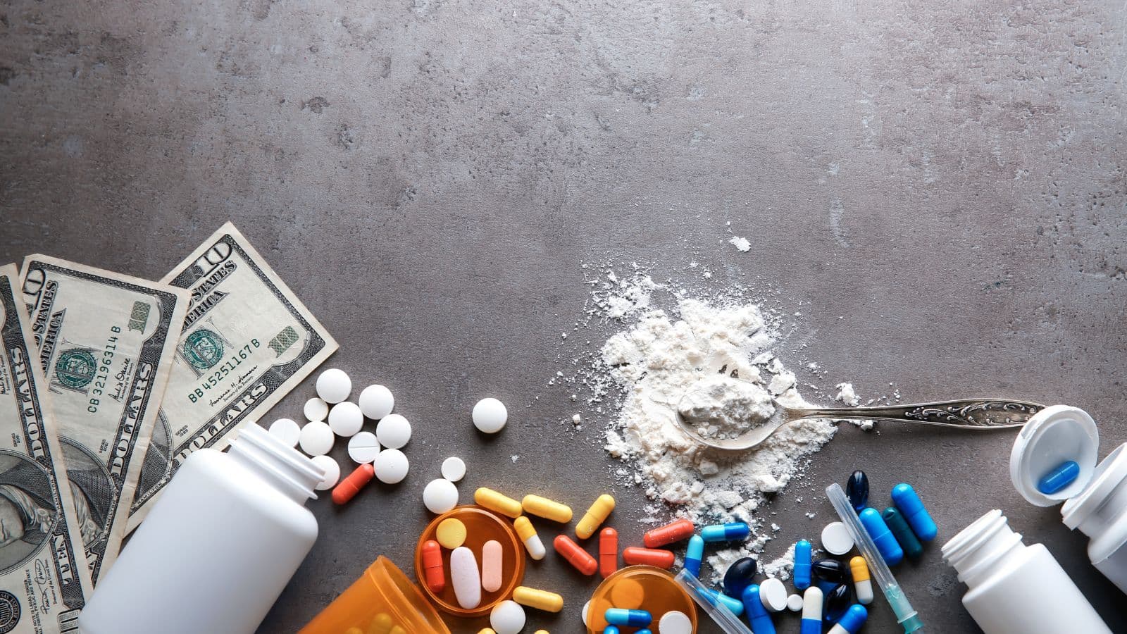 Comprimés, poudre et argent symbolisant le trafic de drogue