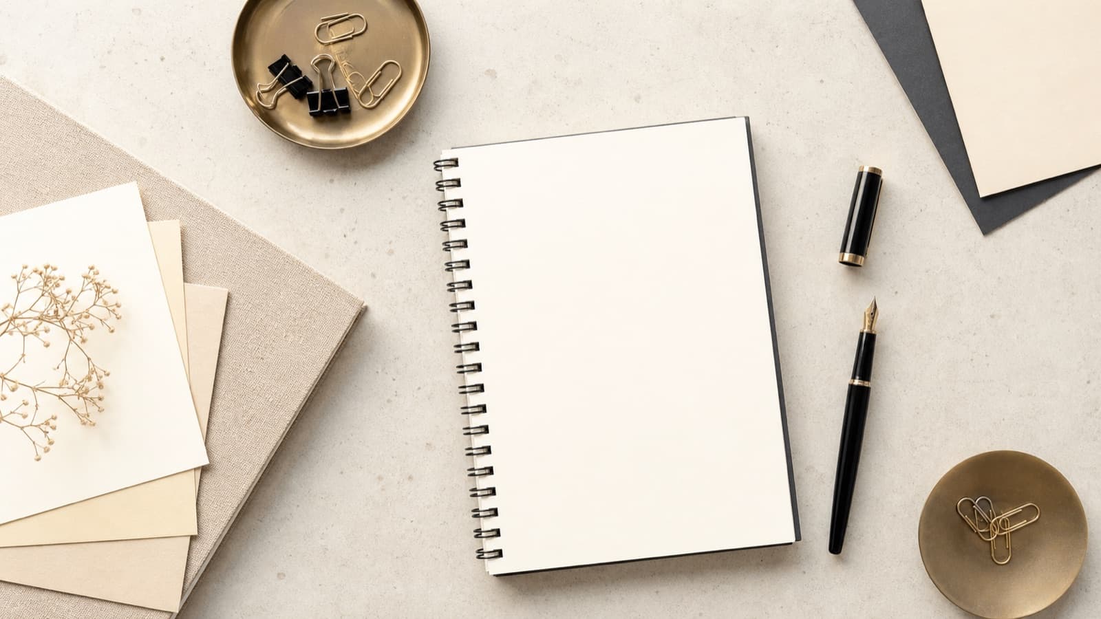 Papeterie élégante, carnet vierge et stylo sur une table claire