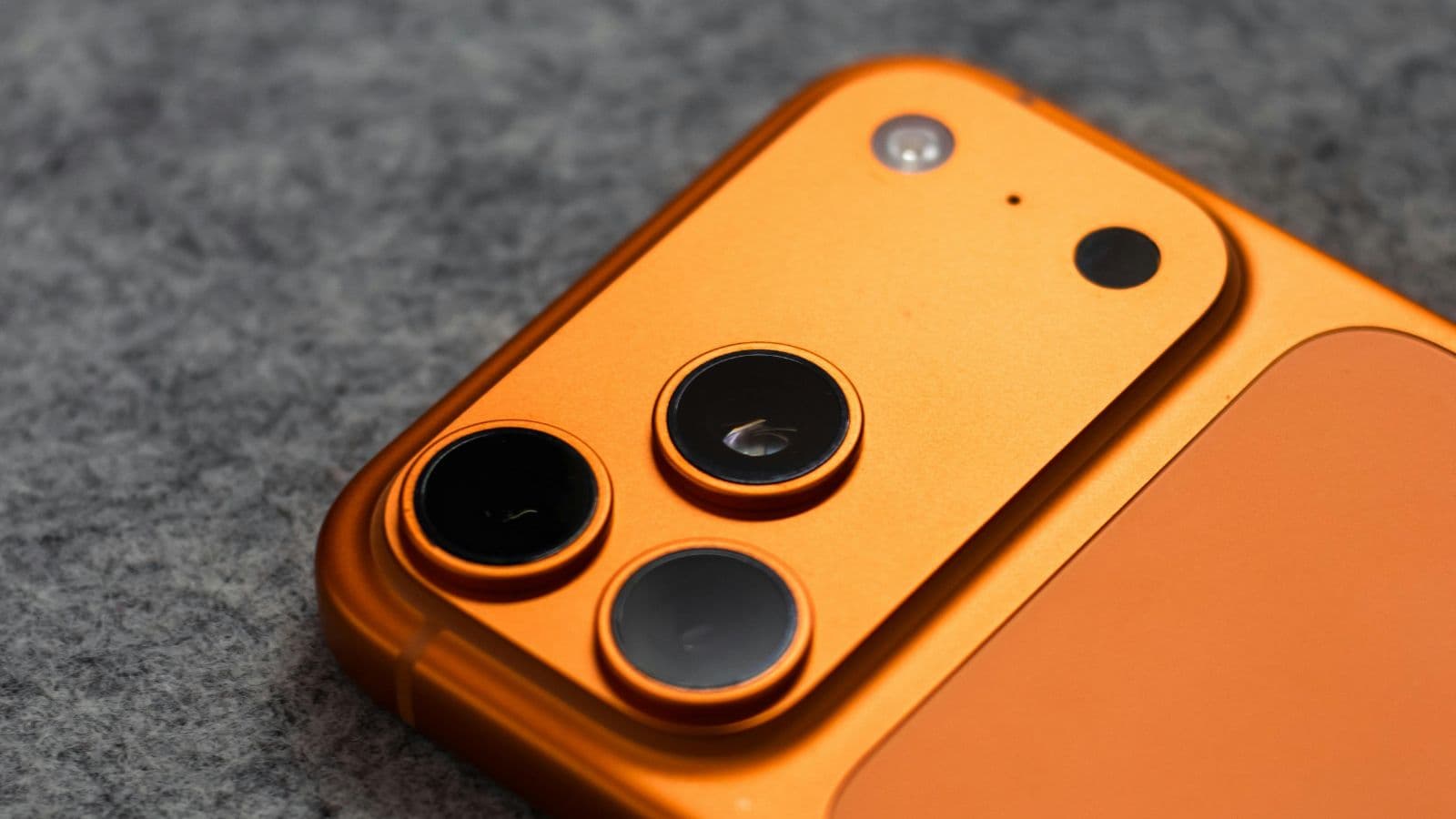 Gros plan sur les objectifs photo d'un smartphone orange